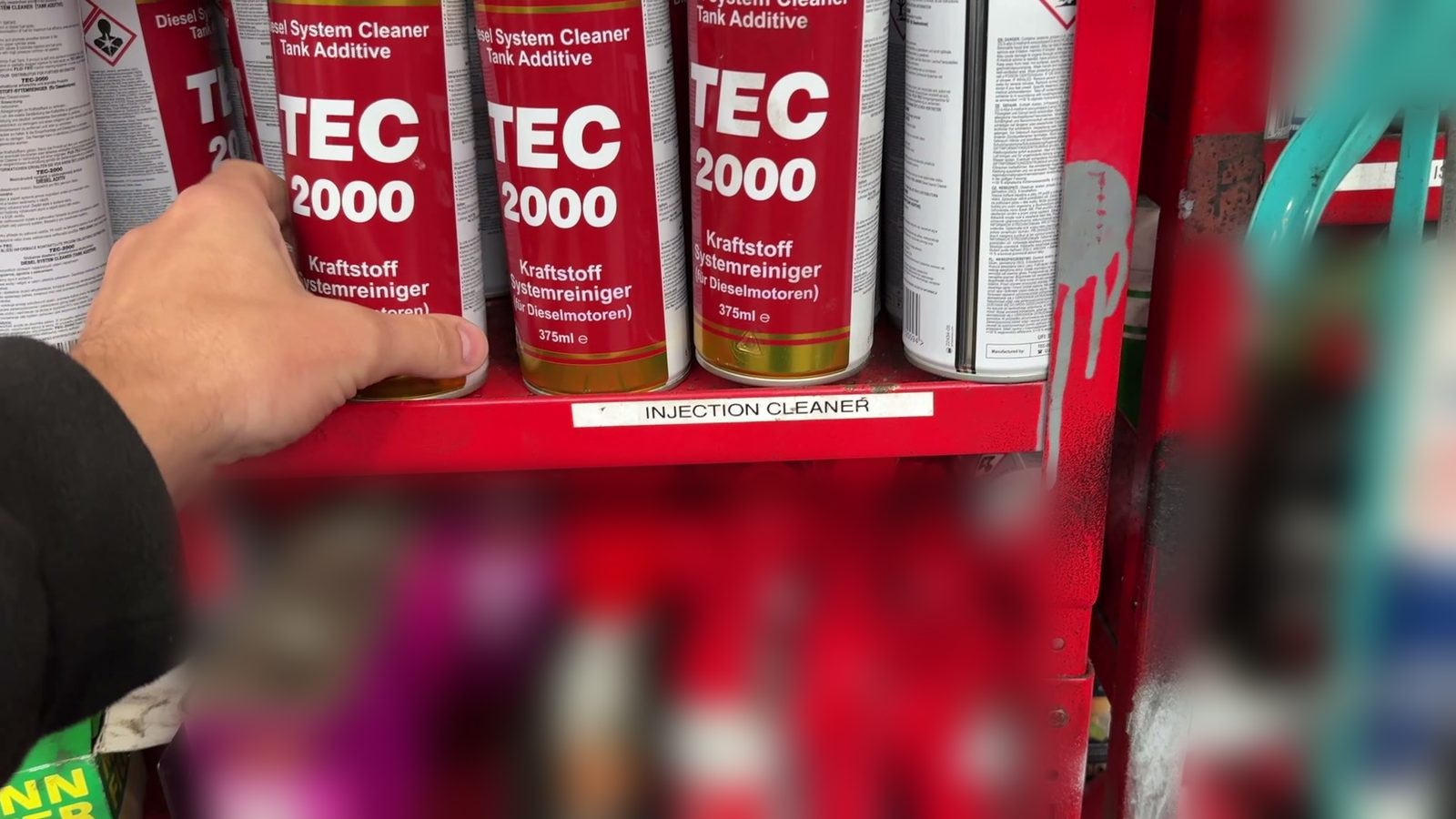 A can of TEC 2000 Diesel System Cleaner being taken from the workshop shelf.